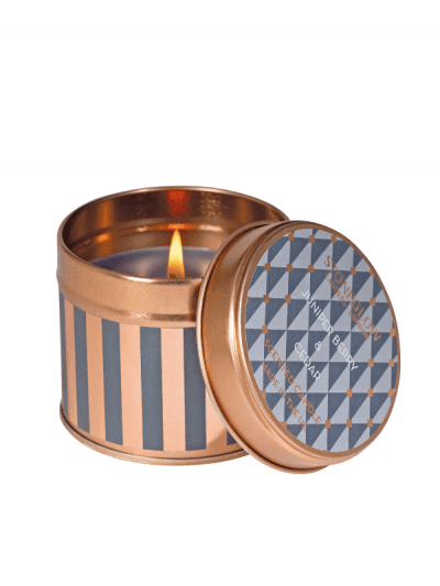 StoneGlow - juniper & cedar candle in a tin, flame is burning