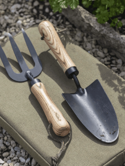 Gardening tools - a fork and trowel set on a kneeling pad