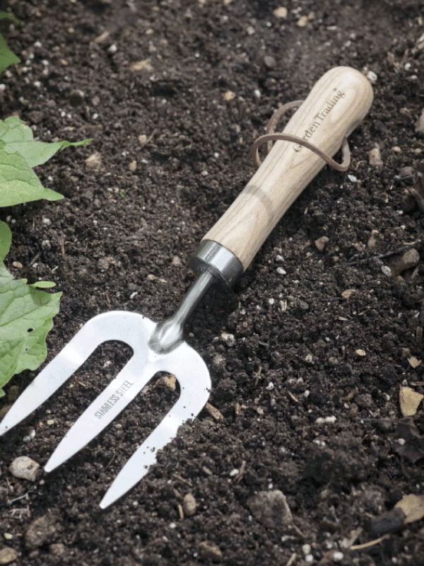 Garden Trading Hand Fork, garden fork lying in a garden soil bed