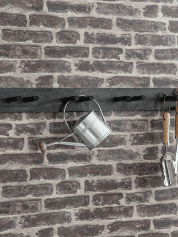 Garden Trading Tool Rail hanging garden tools on a brick wall