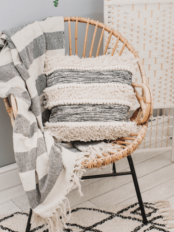 Black and white striped cushion on a wicker chair in a home