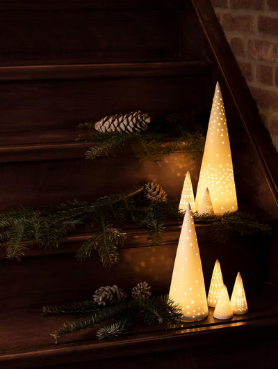 Räder porcelain light tree glowing softly, made from white matte porcelain with delicate cut-out design, perfect for Christmas table or mantel display.