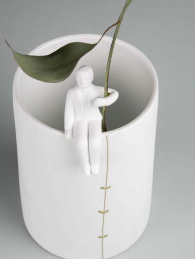 White porcelain vase with 3D gardener figure and gold climbing plant detail by Räder Design.