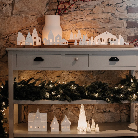 Mini porcelain LED fir tree with perforated pattern, battery-operated, festive holiday decoration.