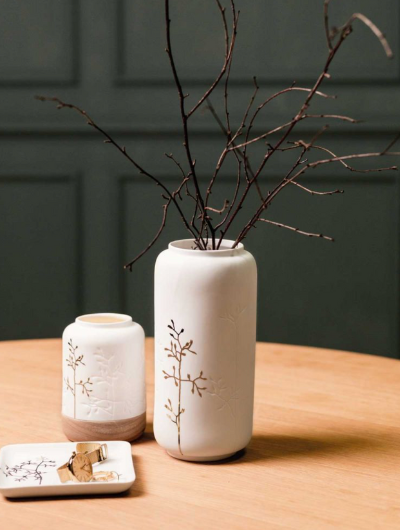 Elegant white porcelain vase with embossed twig design and a golden twig motif, glazed inside and unglazed outside.