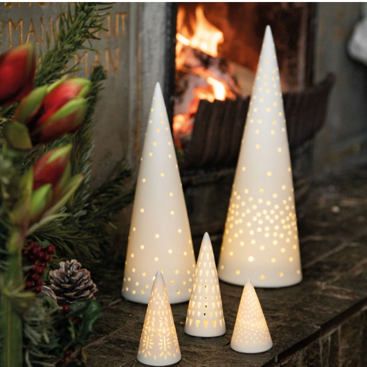 Mini porcelain LED fir tree with perforated pattern, battery-operated, festive holiday decoration.