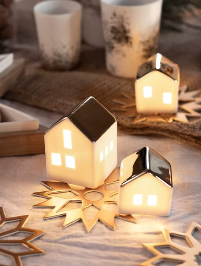 Mini porcelain LED illuminated house by Räder Design glowing softly, 4.5cm tall, battery-operated decorative light.