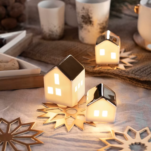 Mini porcelain LED illuminated house by Räder Design glowing softly, 4.5cm tall, battery-operated decorative light.