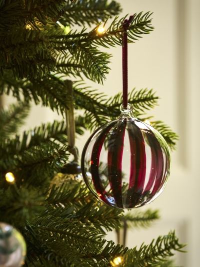 Set of three clear glass Purton Striped Christmas Baubles with hand-painted berry stripes and matching velvet ribbons, hanging on a Christmas tree.