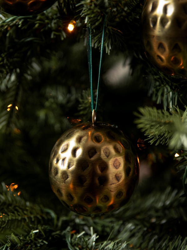 Set of three Ardington Hammered Baubles in antique brass with dark green velvet ribbons, perfect for a traditional red, green, and gold Christmas tree.