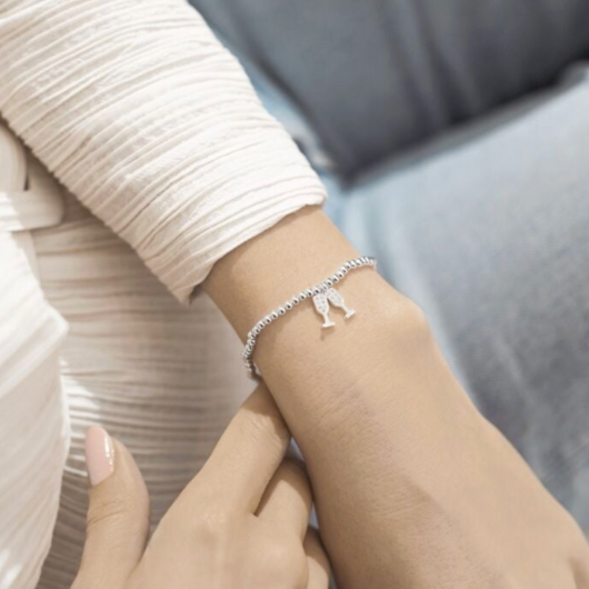 Joma Jewellery A Little Birthday Cheers silver-plated bracelet with champagne flute charms on sentiment card.
