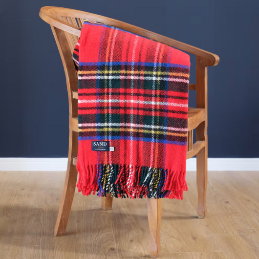 Royal Stewart tartan wool throw with red twisted tassels, draped over a sofa.