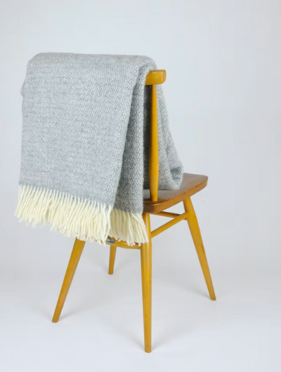 Soft Grey Wool Illusion Blanket Throw with cream tassels draped over a sofa