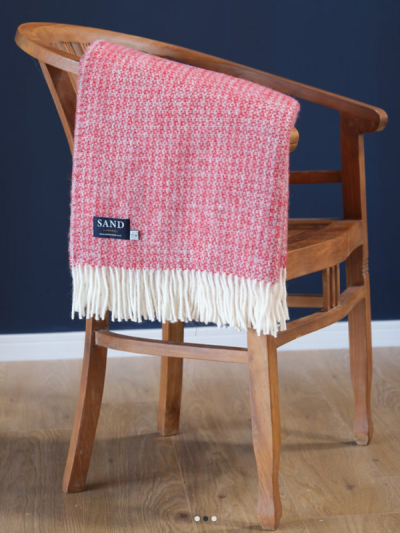 Red and silver 100% wool blanket Throw draped over a chair with cream tasselled edge.
