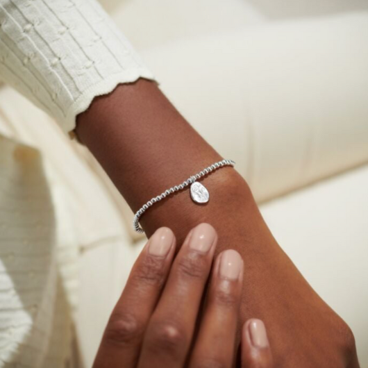 Joma Jewellery Birth Flower October Cosmos silver-plated bracelet with engraved oval charm on pastel sentiment card.