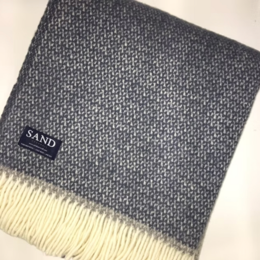 Slate Blue and Grey Wool Illusion Blanket Throw with cream tassels draped on sofa