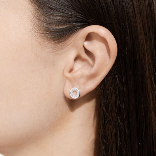 Model wearing Joma Jewellery One in a Million silver-plated stud earrings symbolising love and uniqueness.