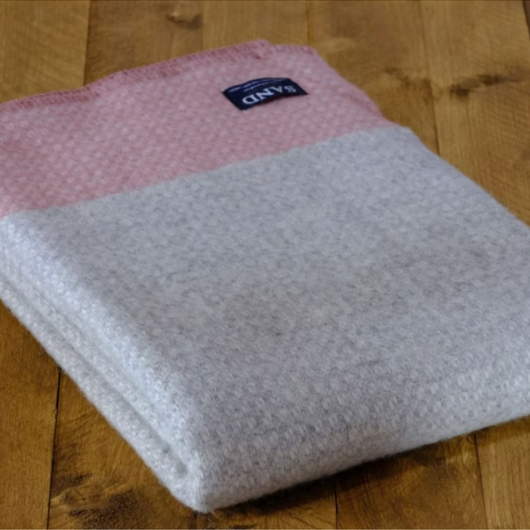 Crossweave Dusty Pink and Light Grey Wool Cornwall Throw Blanket draped on a sofa