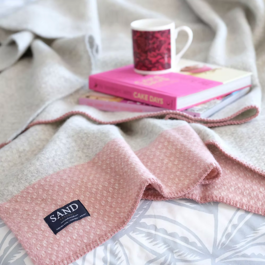 Crossweave Dusty Pink and Light Grey Wool Cornwall Throw Blanket draped on a sofa