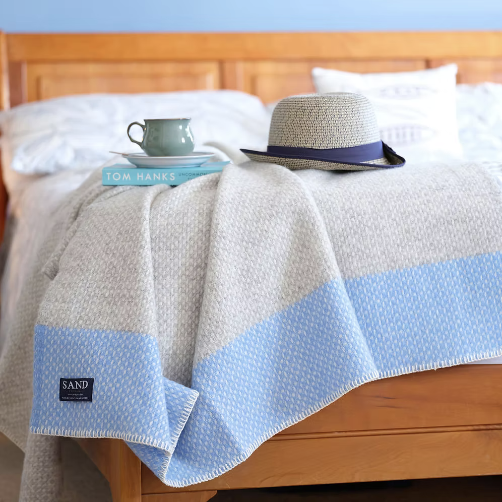 Crossweave Sea Blue Pure New Wool Blanket Throw with light grey base and bright blue stripe, folded neatly.with light grey base and bright blue stripe, folded neatly on a bed.