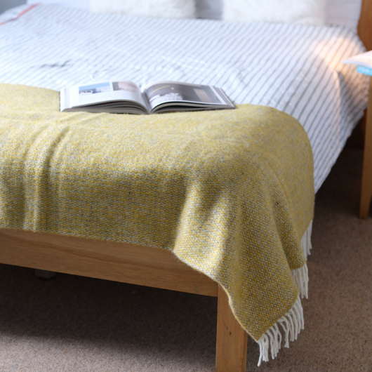 Illusion Yellow and Grey Wool Blanket Throw with cream tassels draped over sofa