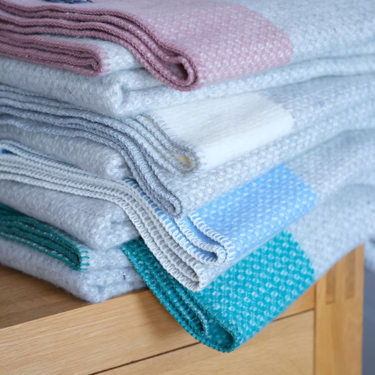 Crossweave Dusty Pink and Light Grey Wool Cornwall Throw Blanket draped on a sofa