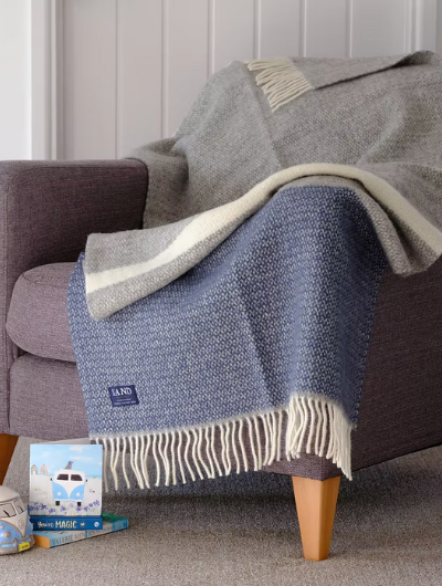 Slate Blue and Grey Wool Illusion Blanket Throw with cream tassels draped on sofa