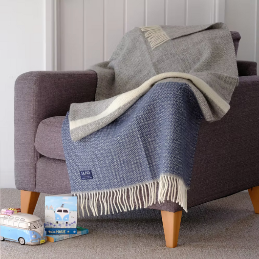 Slate Blue and Grey Wool Illusion Blanket Throw with cream tassels draped on sofa