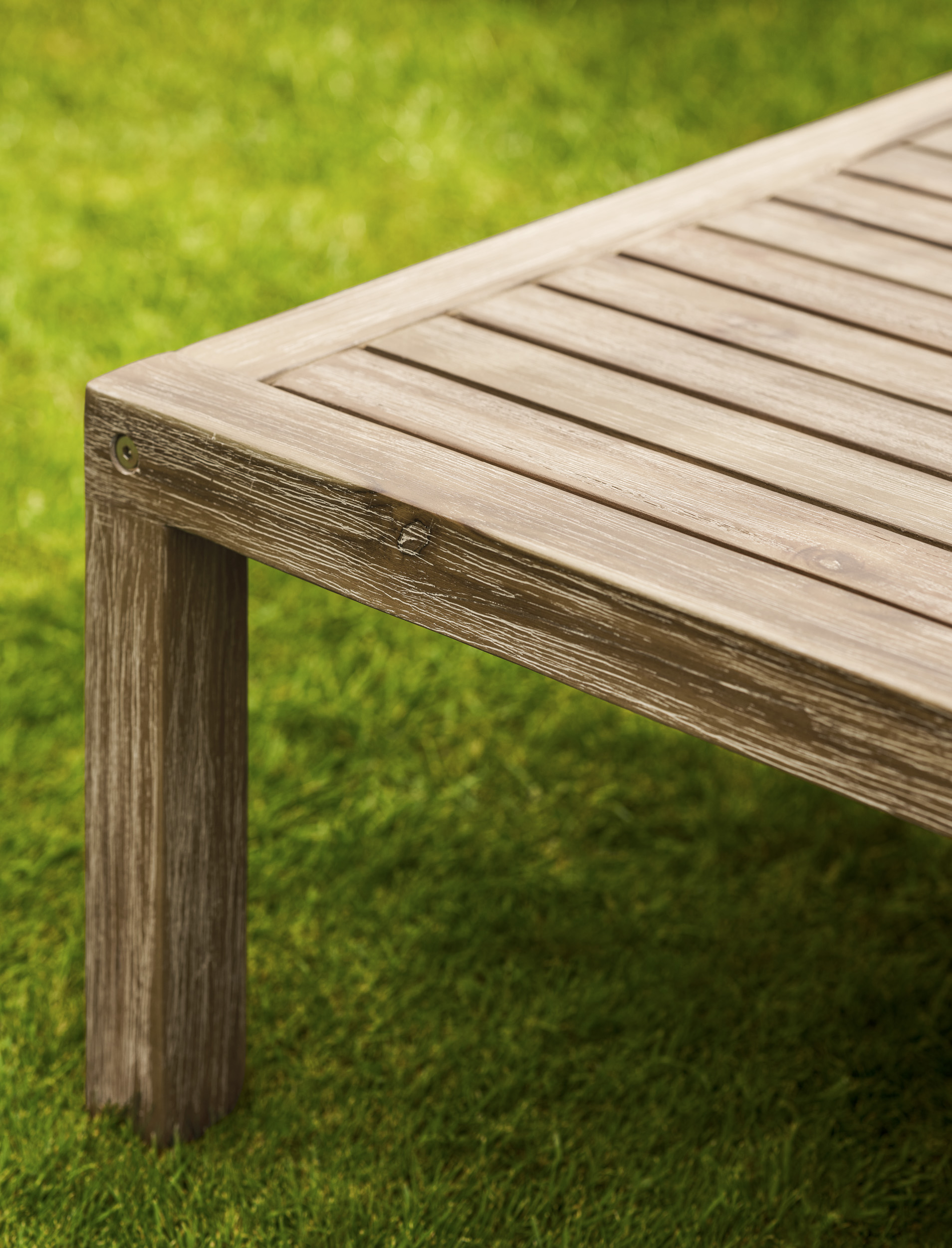 Garden Trading Porthallow Dark Natural acacia corner sofa set with matching armchair and coffee table on a garden patio. Sizes