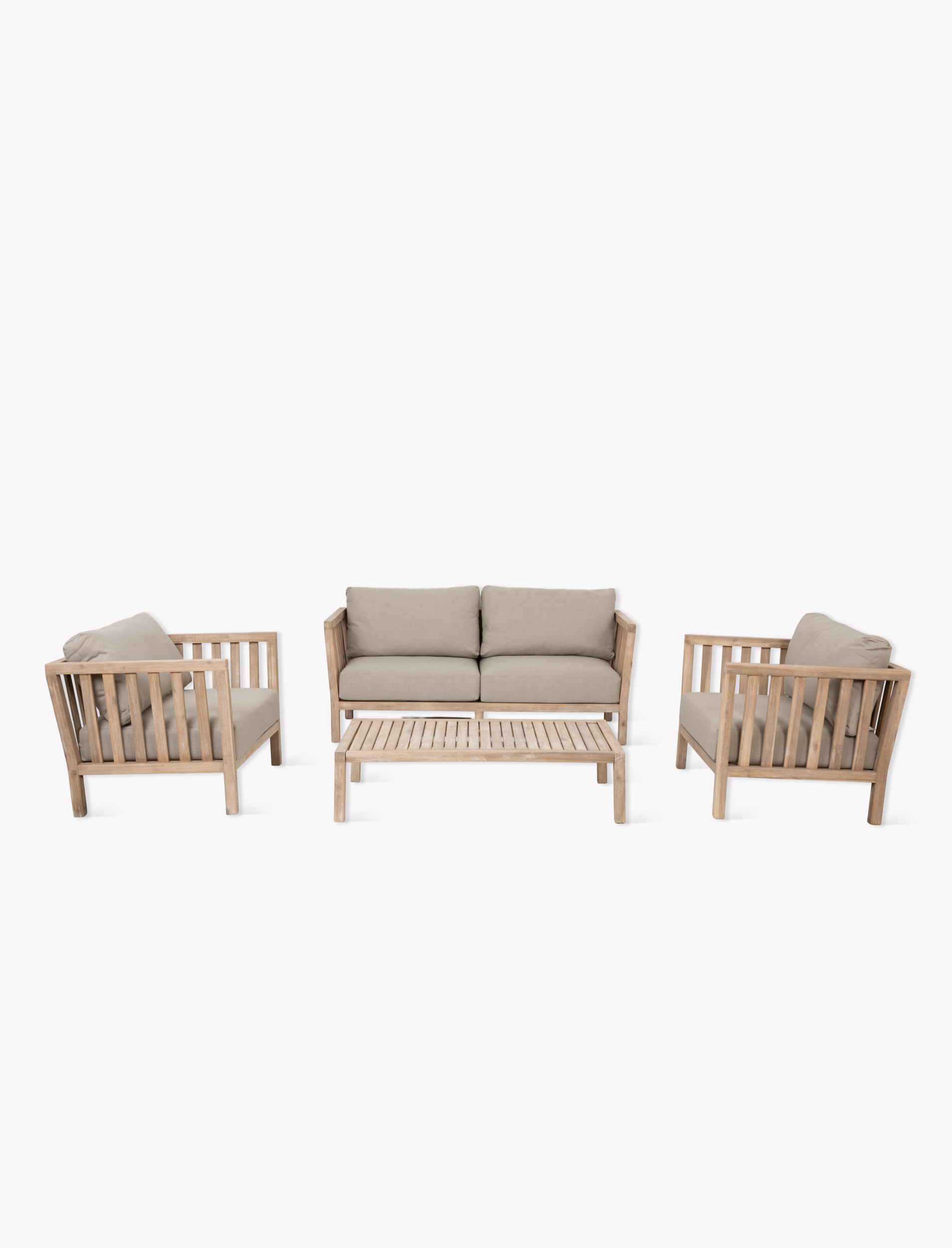 Garden Trading Porthallow 2 seater sofa set in natural acacia wood with matching armchairs and coffee table outdoors.