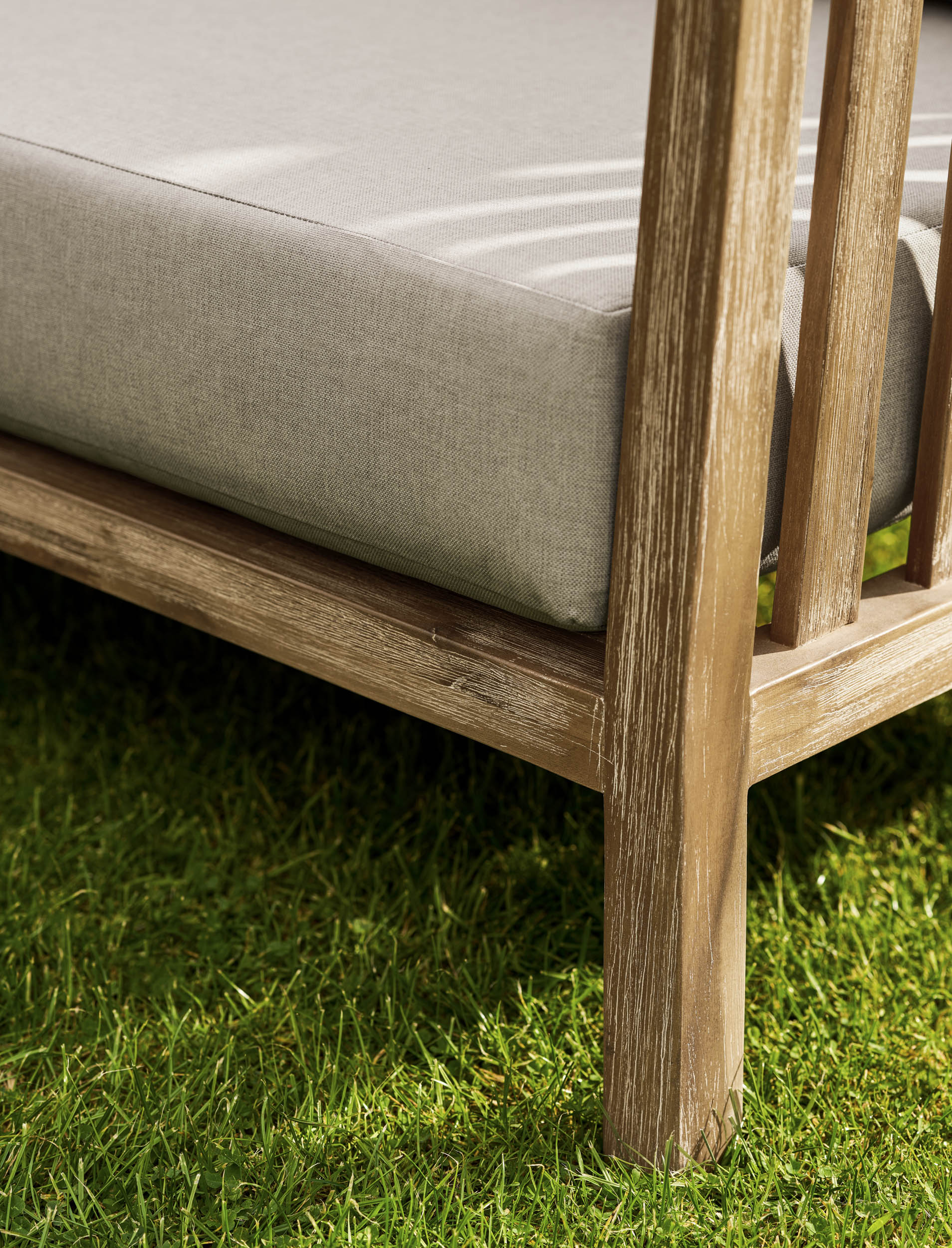Garden Trading Porthallow Dark Natural acacia corner sofa set with matching armchair and coffee table on a garden patio. Sizes
