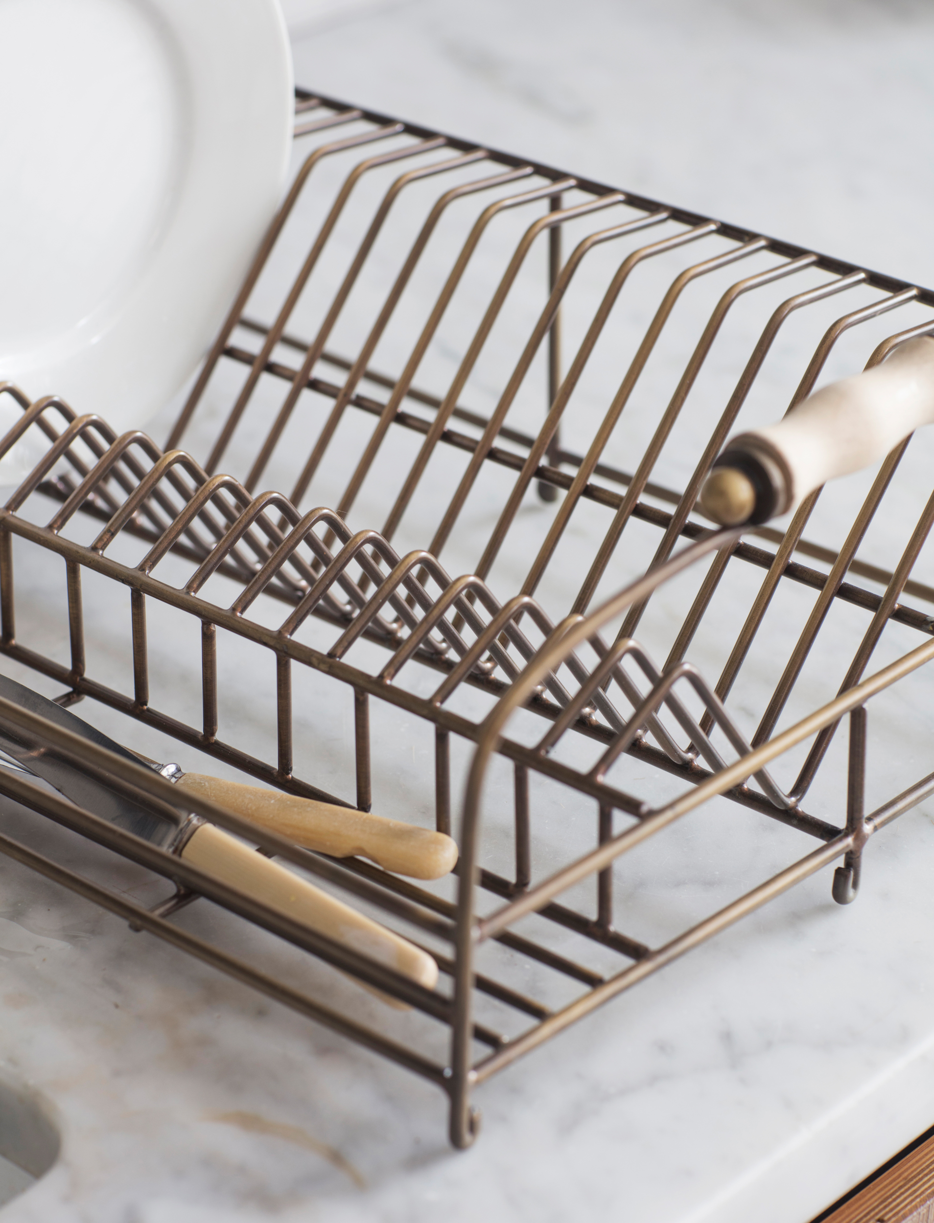 Garden Trading Brompton wirework dish rack with antique brass finish, wooden handles, and plate storage compartments.