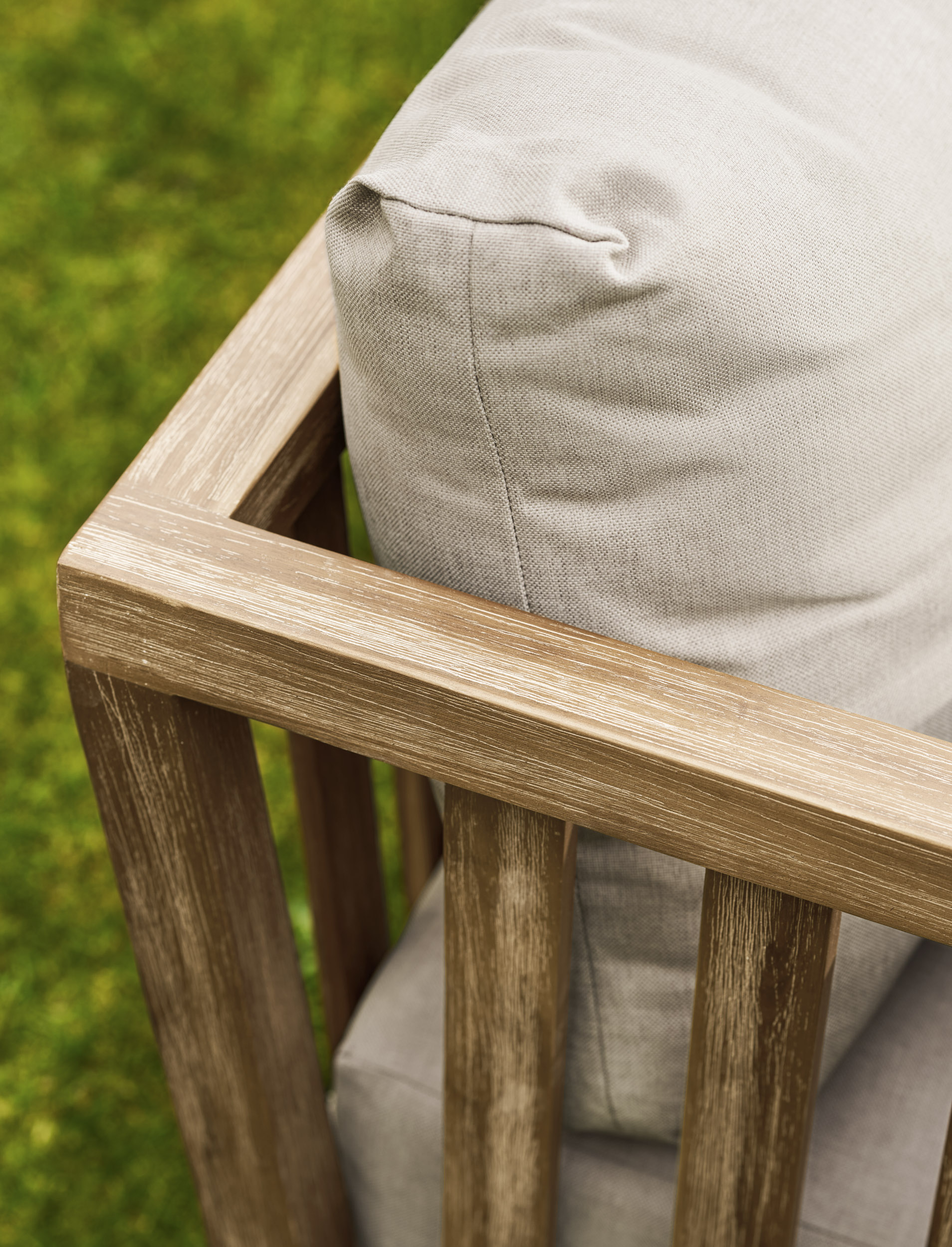 Garden Trading Porthallow Dark Natural acacia corner sofa set with matching armchair and coffee table on a garden patio. Sizes
