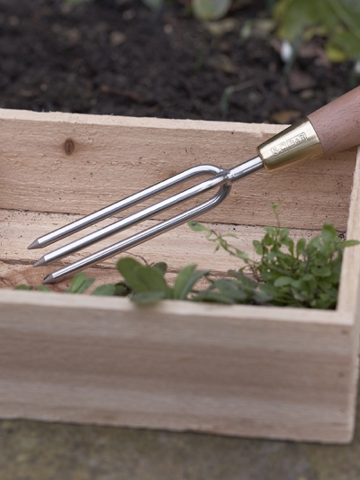 Sophie Conran stainless steel three-pronged garden weeder with FSC beech wood handle and brass ferrule.